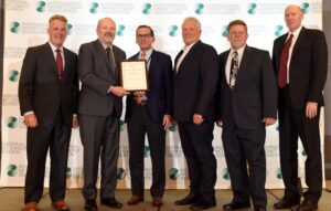 Six leaders from Milwaukee Regional Medical Center and Ever-Green on stage holding award