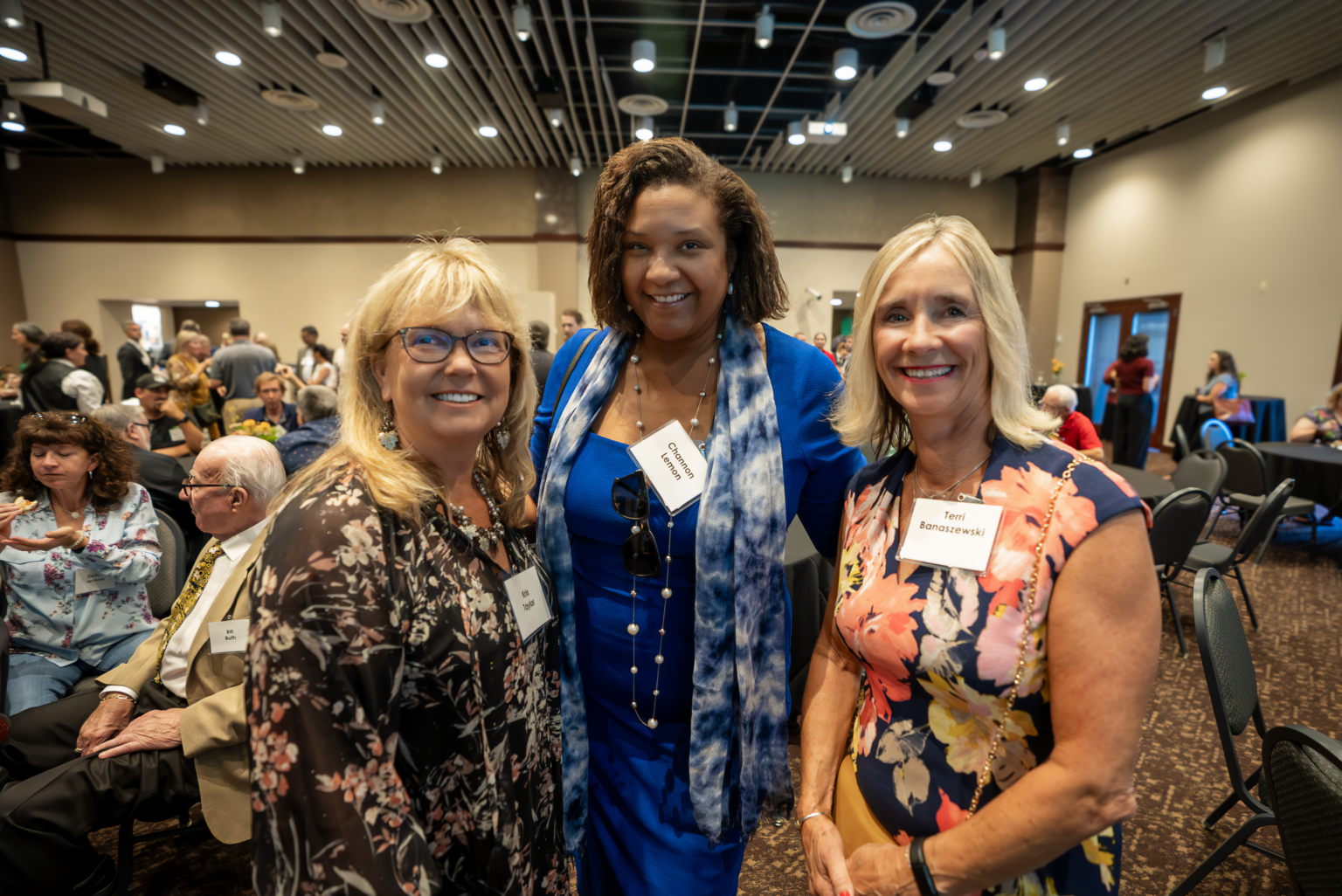 Two Ever-Green board members alongside a community member at a celebration event